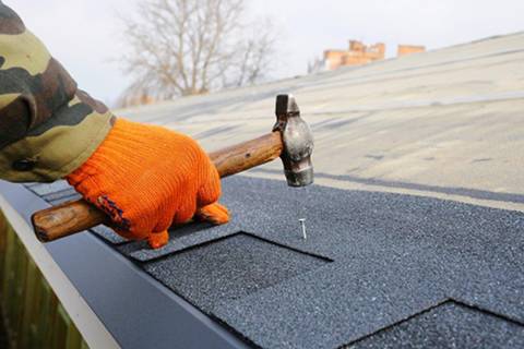 A worker hammering in a nail